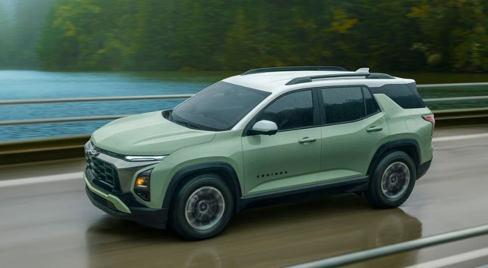 Green 2025 Chevy Equinox ACTIV driving over a bridge