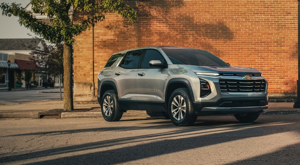 Silver 2025 Chevy Equinox for sale parked near a brick building