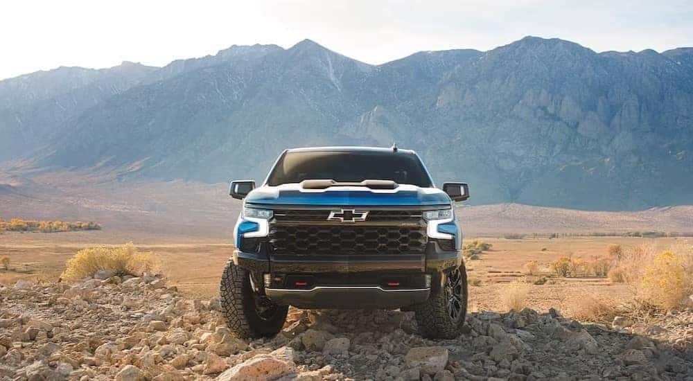 A blue 2024 Chevy Silverado 1500 ZR2 is shown parked off-road after viewing a Chevy Silverado 1500 for sale in Birmingham.