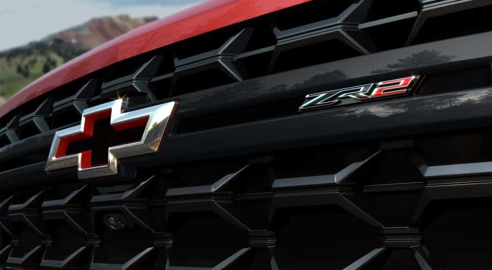 Close-up on the grille and badge of a red 2024 Chevy Silverado 2500 HD ZR2 for sale in Birmingham.