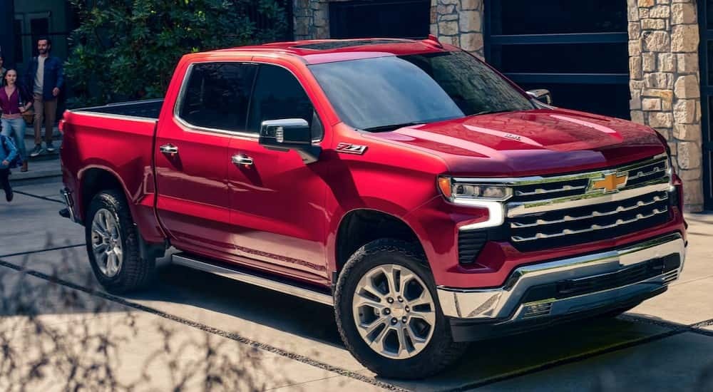 A red 2025 Chevy Silverado 1500 parked on a driveway.