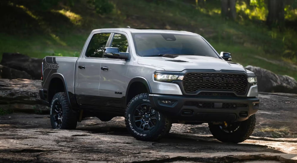White 2026 Ram 1500 parked off-road in a forest.