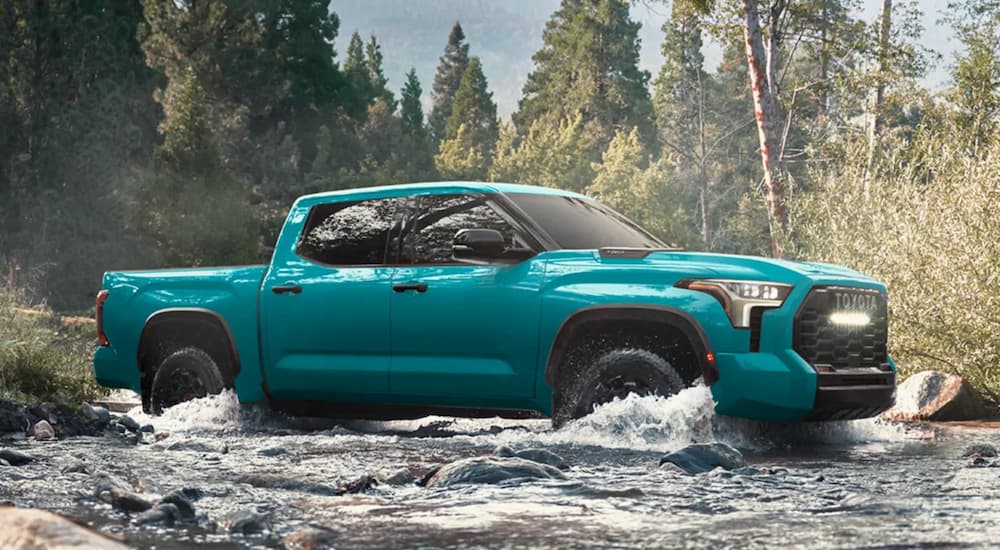 Blue 2026 Toyota Tundra TRD Pro driving over a shallow river.