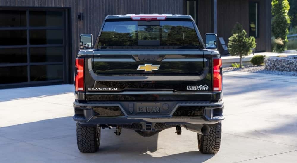 A black 2025 Chevy Silverado 2500 HD High Country parked on a driveway.