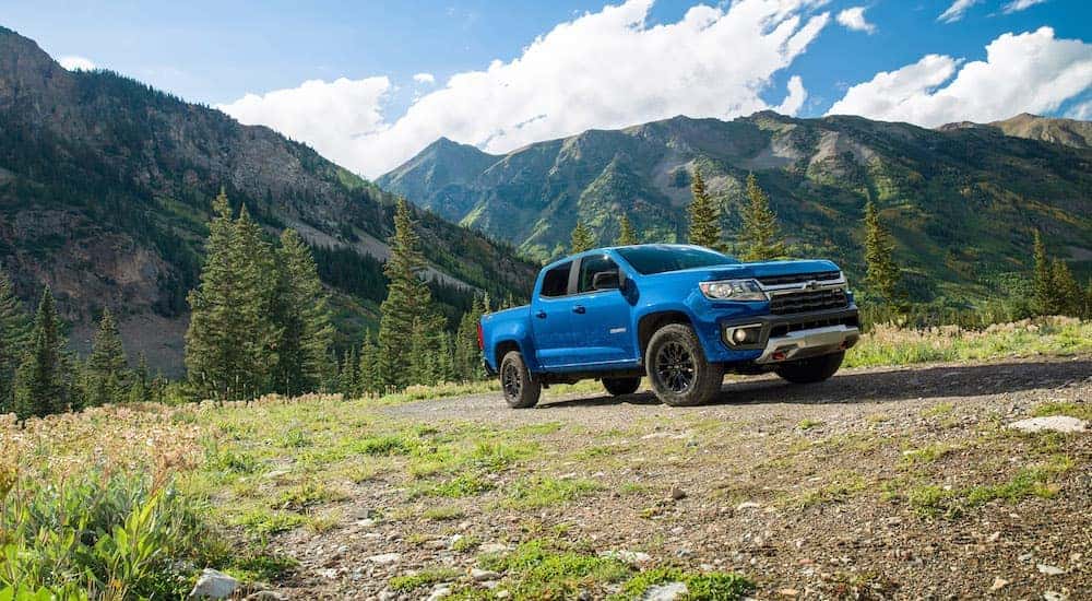 A blue 2021 Chevy Colorado Z71 is shown parked near mountains.