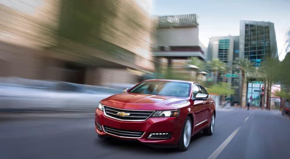 A red 2018 Chevy Impala LTZ is shown speeding on a city street.