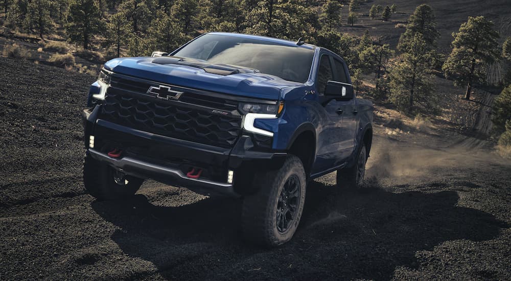 A blue 2026 Chevy Silverado 1500 off-roading on a hill