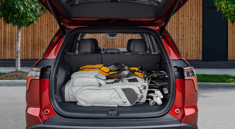 Golf clubs in the rear storage of a red 2026 Chevy Equinox RS