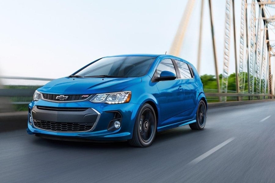 A blue Chevrolet Sonic driving across a bridge