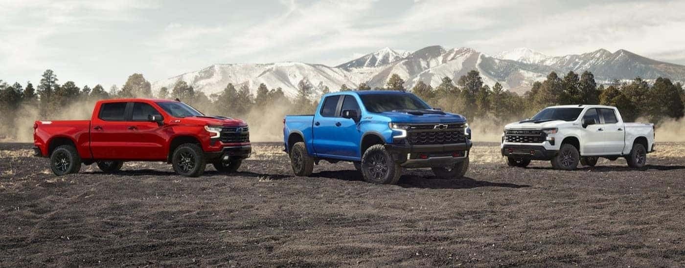 A red, blue and white 2026 Chevy Silverado 1500 parked off-road.