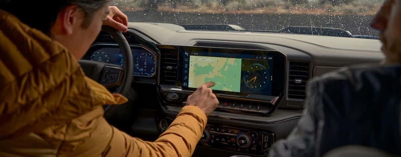 A person using the infotainment screen in a 2026 Chevy Silverado 1500.