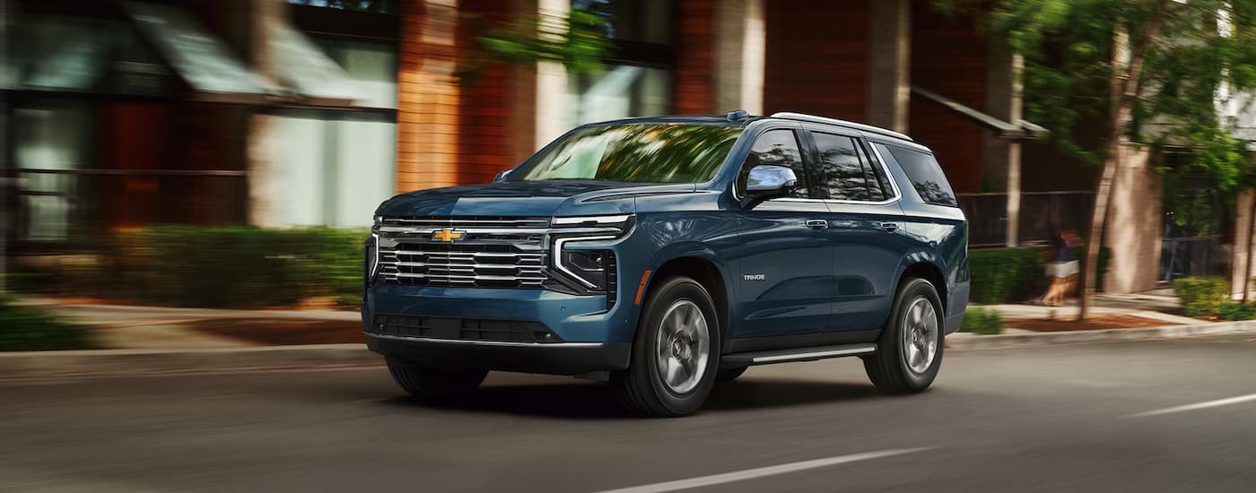 Blue 2026 Chevy Tahoe driving down an open road.