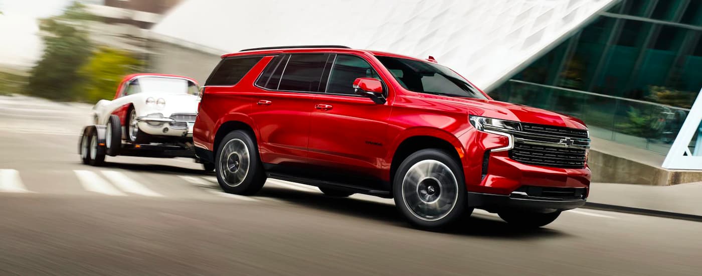 Red 2026 Chevy Tahoe towing a show car.