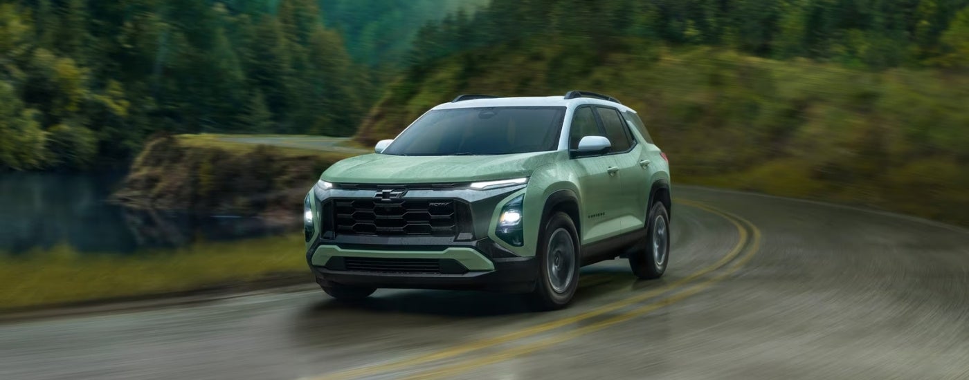 Green 2026 Chevy Equinox driving to a car dealer