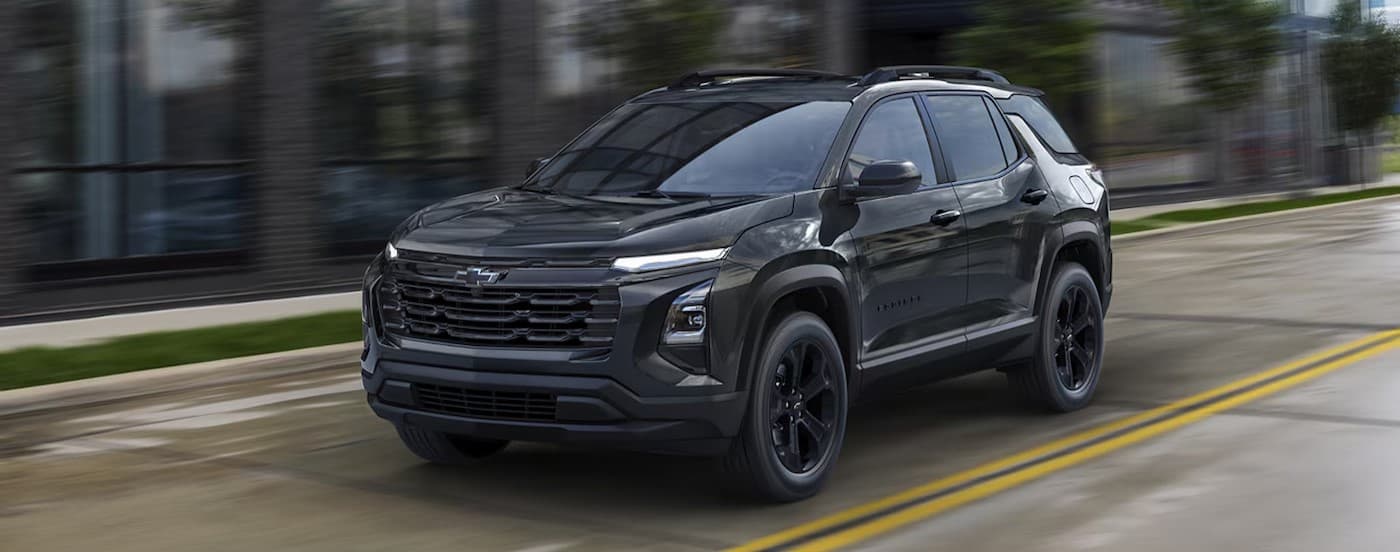 A black 2026 Chevy Equinox driving in a city.