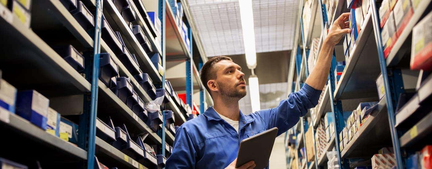 A tech is shown pulling parts off of a shelf.
