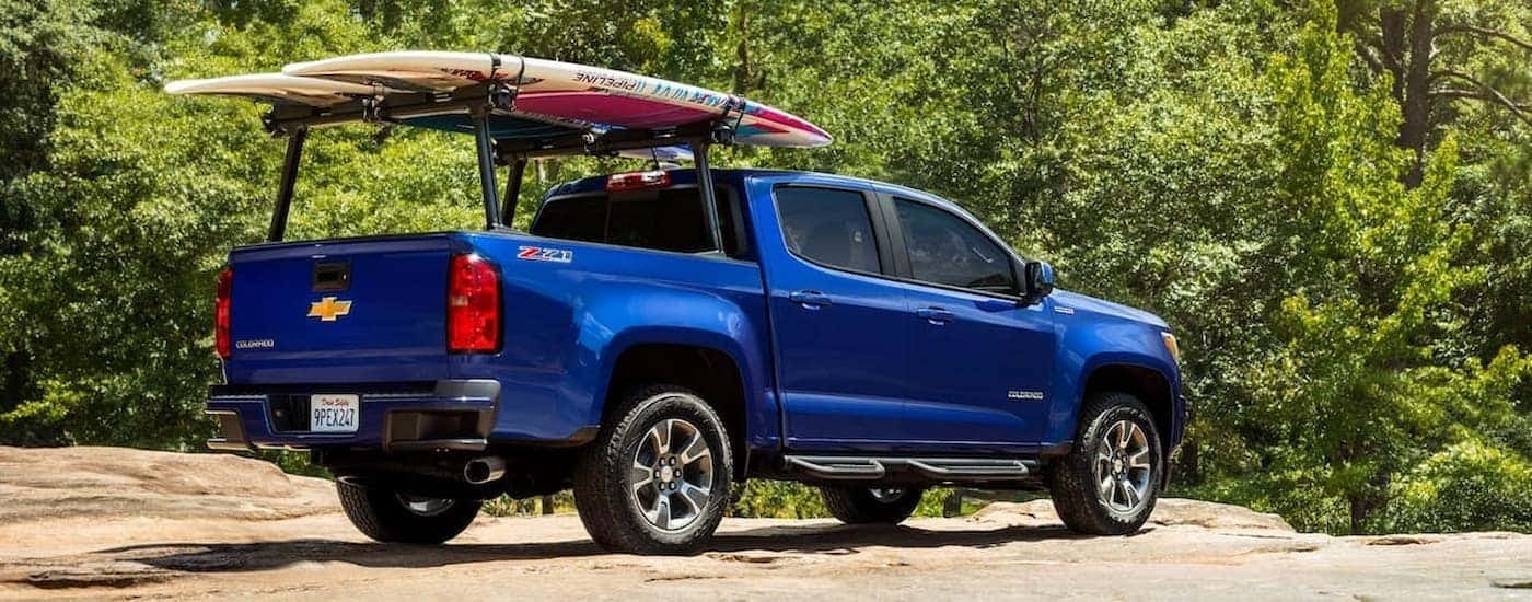 A blue 2019 Chevy Colorado Z71 is shown from a rear angle parked on a sandy lot.