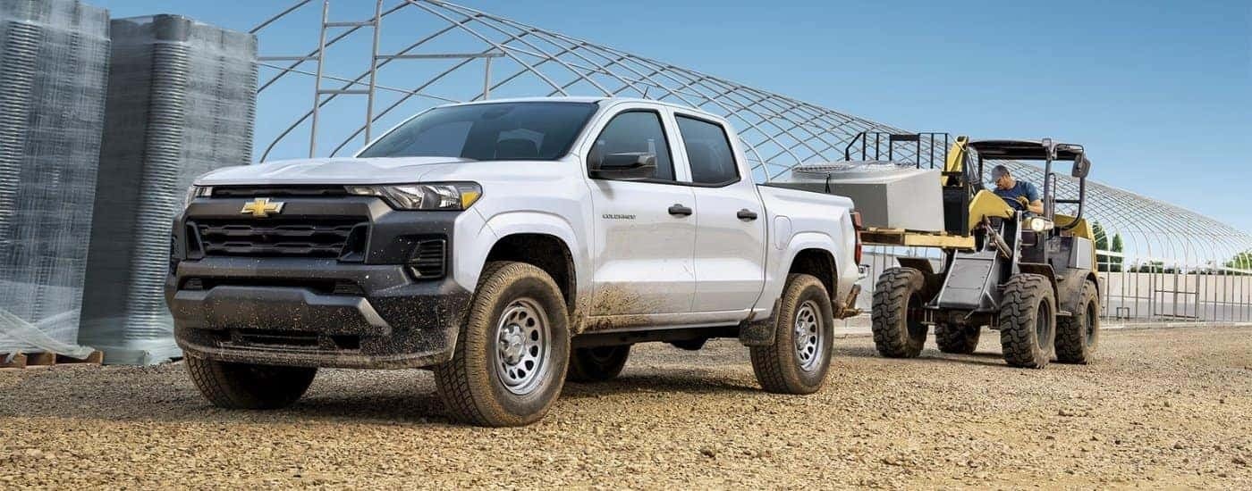 A white 2024 Chevy Colorado WT being loaded with equipment.
