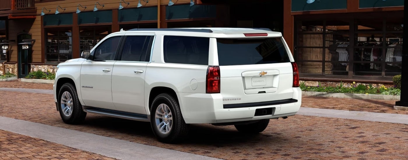 White 2017 Chevy Suburban parked near a use Chevy dealership