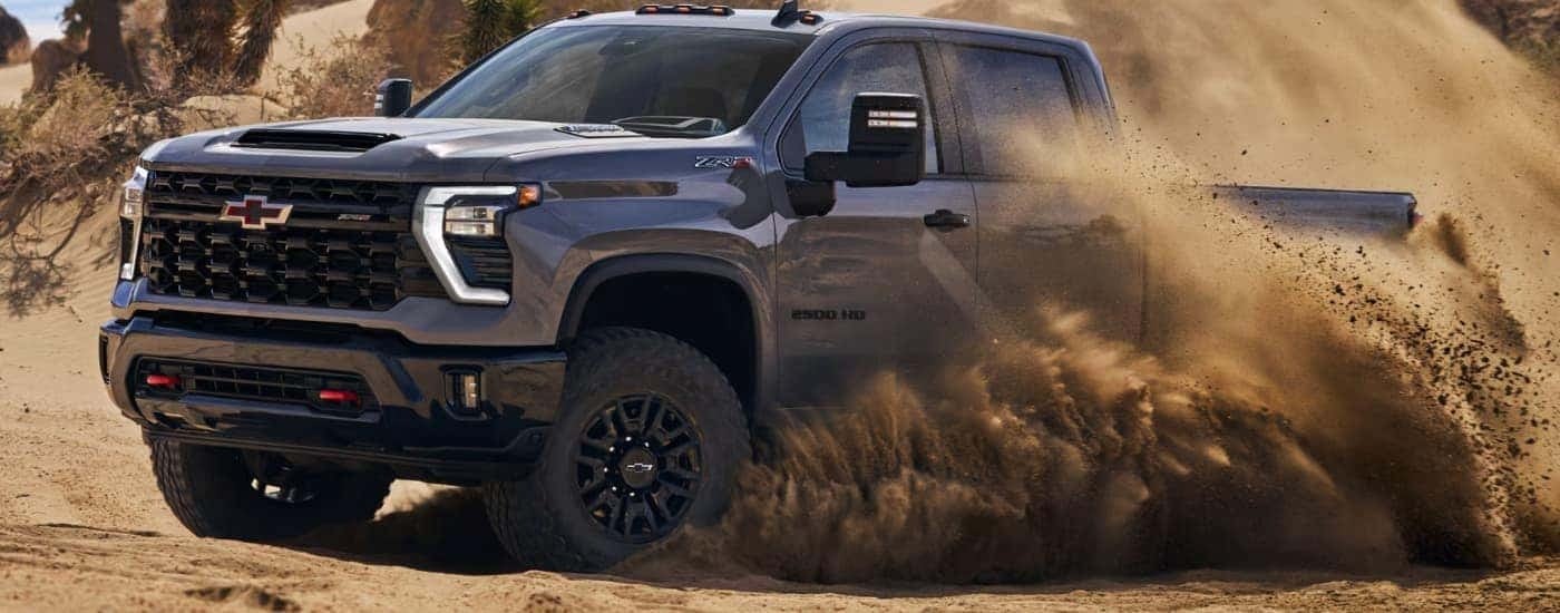 A gray 2026 Chevy Silverado 2500 HD off-roading in sand